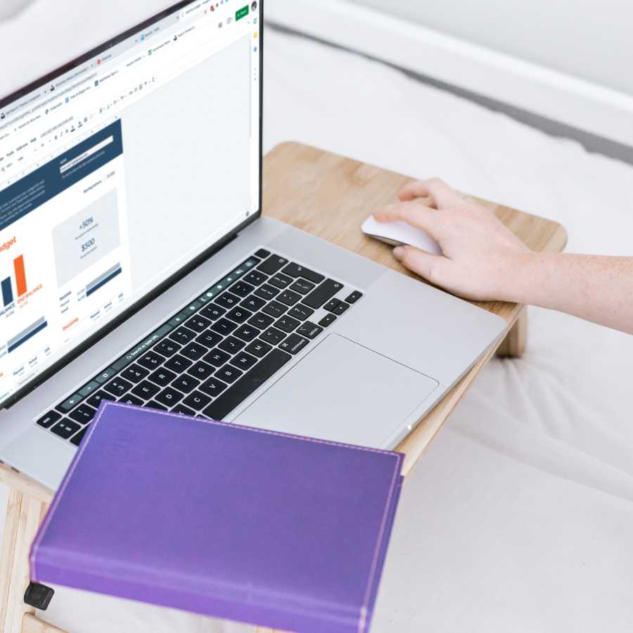 Mano al computer che visualizza grafici e prenotazioni di viaggio